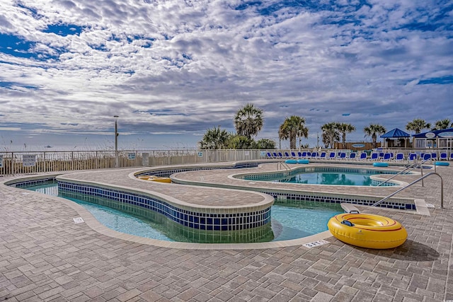 view of pool featuring a patio area and a hot tub