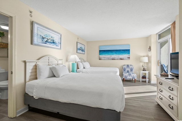 bedroom with dark hardwood / wood-style floors and a textured ceiling