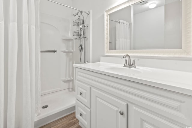 bathroom with vanity, a textured ceiling, a shower with shower curtain, and wood-type flooring