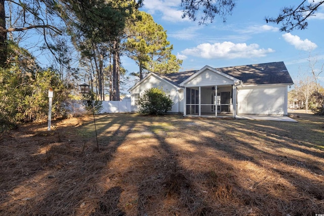 back of house with a yard and a sunroom