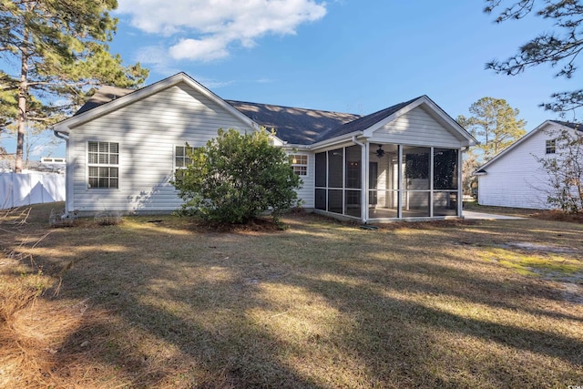 rear view of house with a lawn and a sunroom