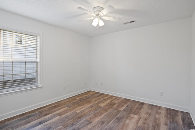 empty room featuring ceiling fan, dark hardwood / wood-style floors, and a textured ceiling