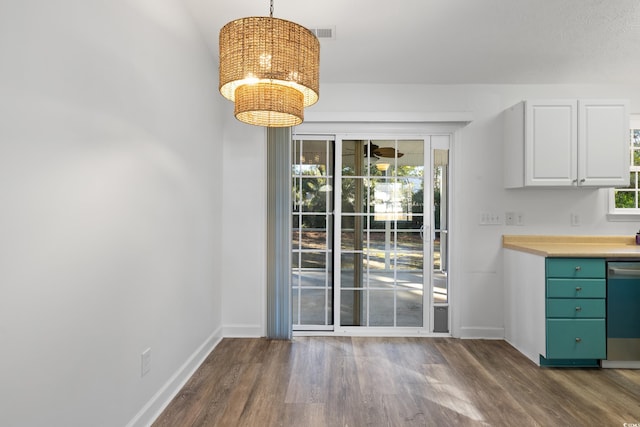 unfurnished dining area with a notable chandelier and dark hardwood / wood-style flooring