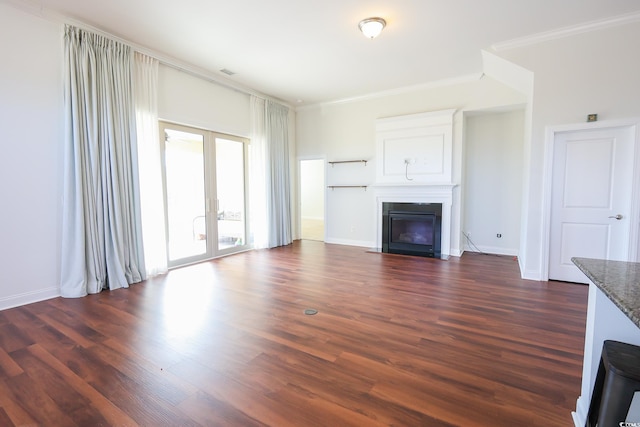 unfurnished living room with crown molding, dark hardwood / wood-style floors, and french doors