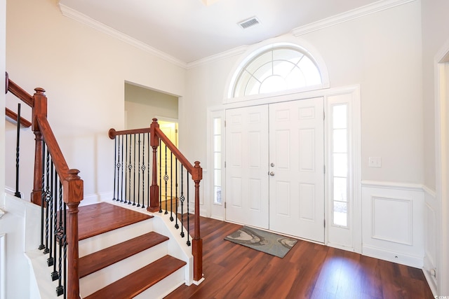 foyer with ornamental molding and dark hardwood / wood-style floors