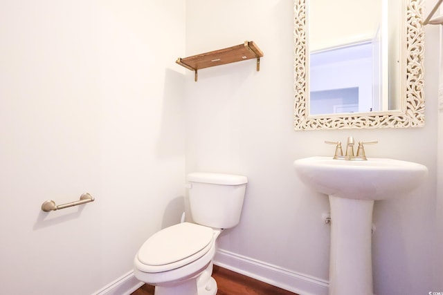 bathroom with hardwood / wood-style floors, sink, and toilet