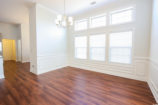 spare room with crown molding, a notable chandelier, and dark hardwood / wood-style flooring