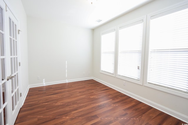 spare room featuring dark hardwood / wood-style floors and french doors