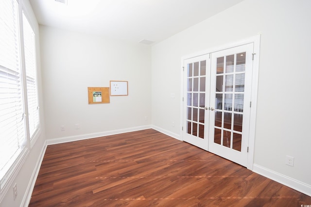 spare room with dark wood-type flooring and french doors