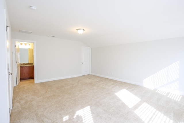 unfurnished bedroom with lofted ceiling and light carpet