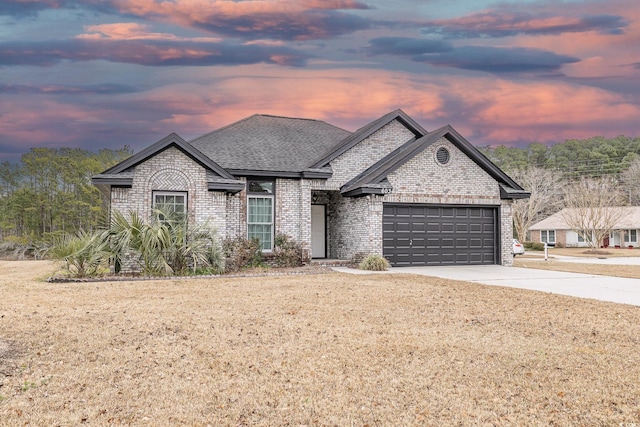 view of front of property with a yard and a garage