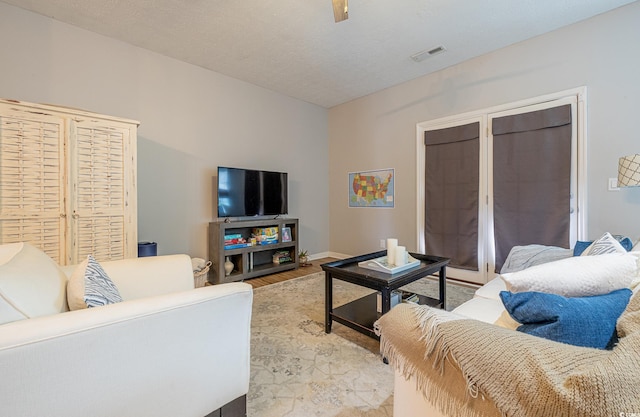 living room with a textured ceiling and light hardwood / wood-style floors