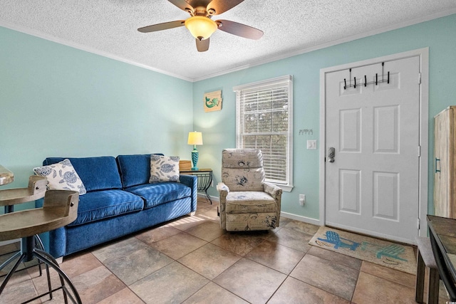 living room with ceiling fan, ornamental molding, tile patterned flooring, and a textured ceiling