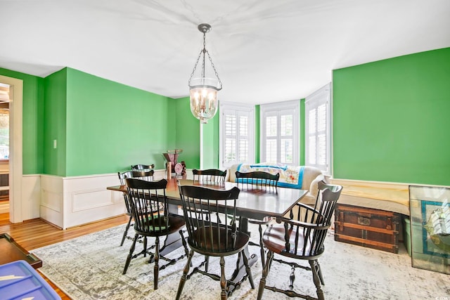 dining space with wood-type flooring and an inviting chandelier