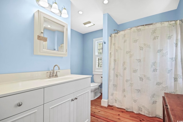 bathroom with hardwood / wood-style flooring, toilet, a shower with shower curtain, and vanity