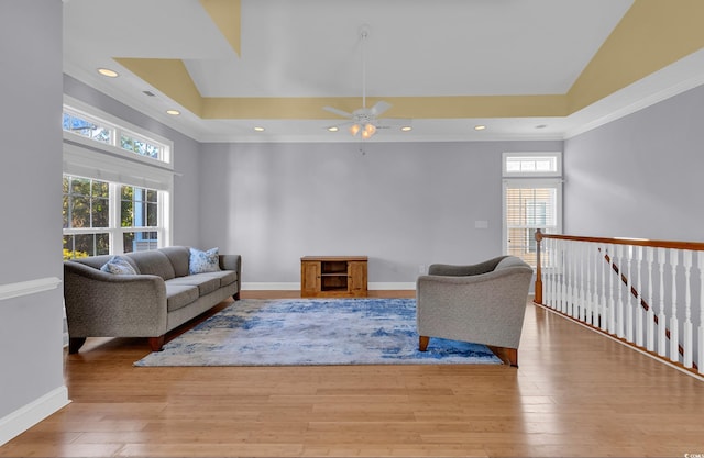 living room with a healthy amount of sunlight, a towering ceiling, and light hardwood / wood-style floors