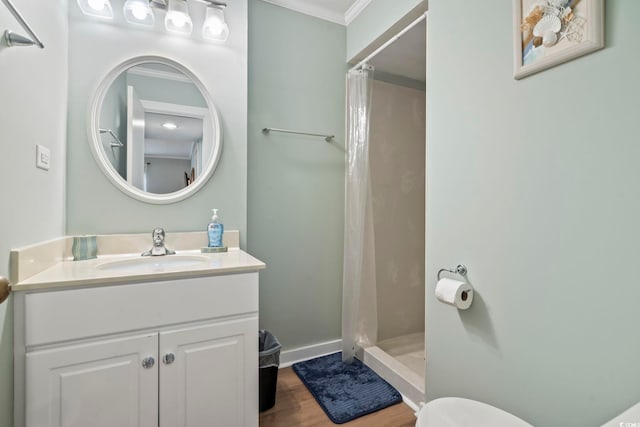 full bathroom featuring toilet, wood finished floors, vanity, a shower stall, and crown molding