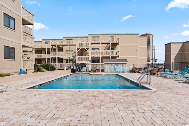 pool with a patio area and fence