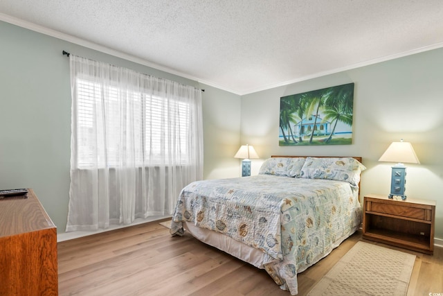 bedroom with crown molding, a textured ceiling, and wood finished floors