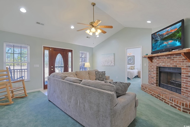 living room with ceiling fan, lofted ceiling, a fireplace, and carpet