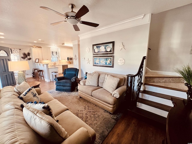 living room featuring hardwood / wood-style flooring, ceiling fan, and ornamental molding