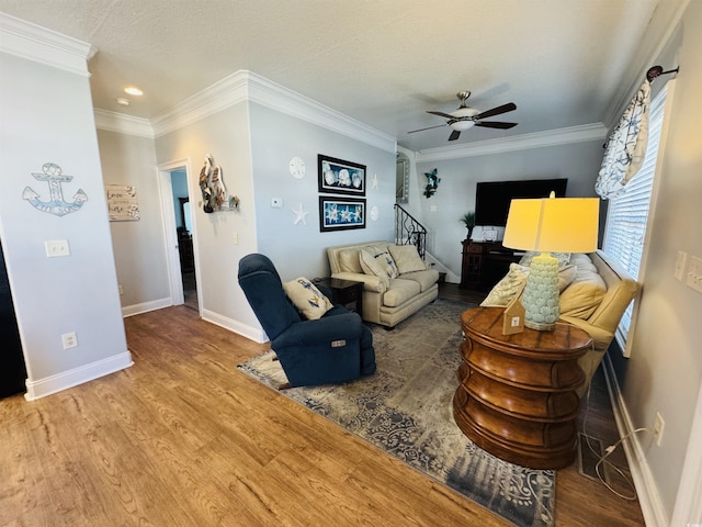 living room with ceiling fan, crown molding, a textured ceiling, and wood-type flooring