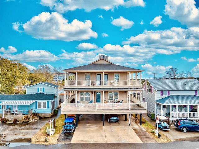 back of property featuring a balcony, covered porch, and a carport