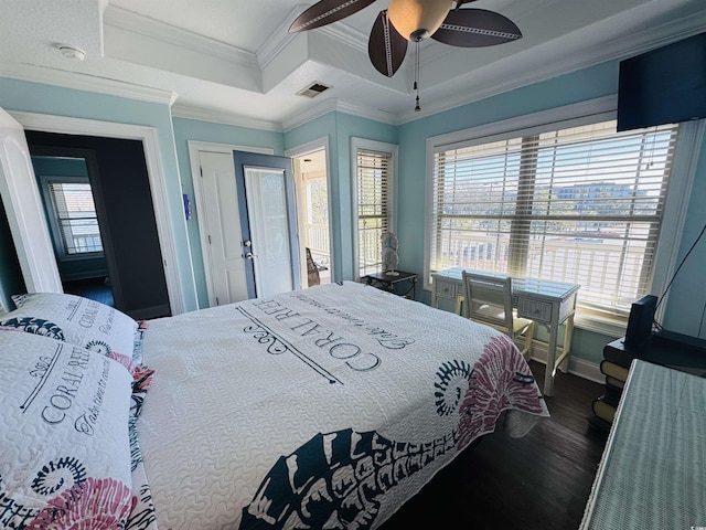 bedroom with ceiling fan, multiple windows, dark hardwood / wood-style floors, and a raised ceiling