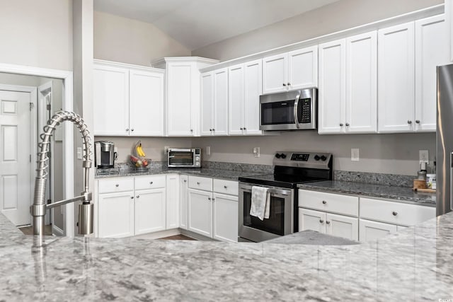 kitchen featuring light stone counters, white cabinets, and stainless steel appliances