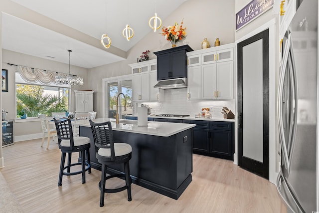 kitchen featuring pendant lighting, white cabinetry, plenty of natural light, stainless steel appliances, and a center island with sink