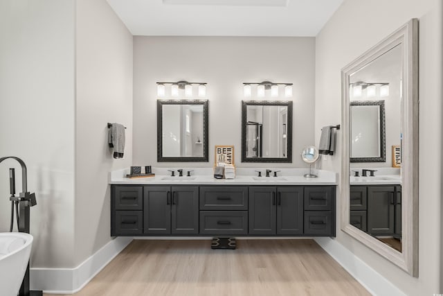 bathroom featuring hardwood / wood-style flooring, vanity, and a bathtub