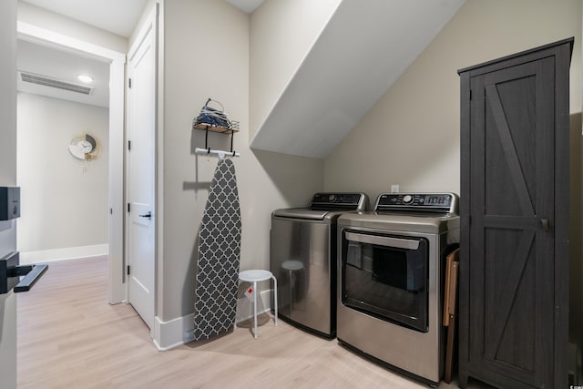 laundry area with independent washer and dryer and light hardwood / wood-style floors