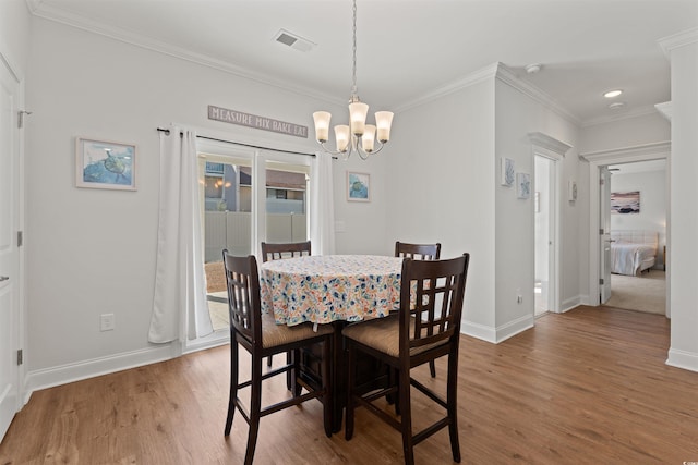 dining area featuring hardwood / wood-style floors, an inviting chandelier, and ornamental molding