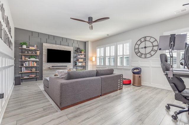 living room featuring ceiling fan and light hardwood / wood-style floors