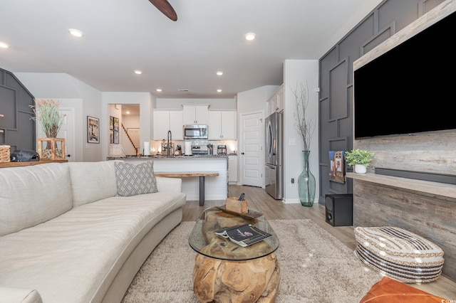 living room with light hardwood / wood-style floors and sink