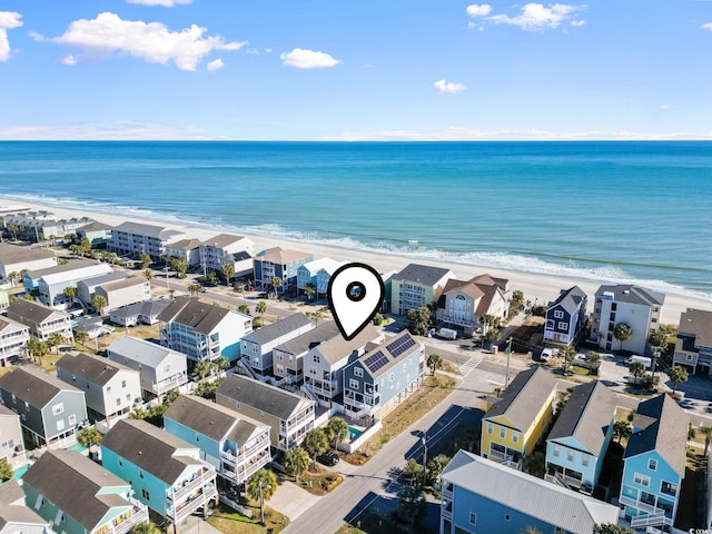 birds eye view of property featuring a water view and a beach view