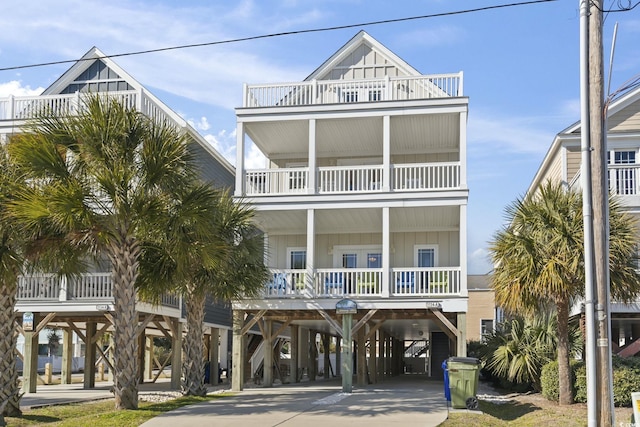 raised beach house featuring a balcony and a carport