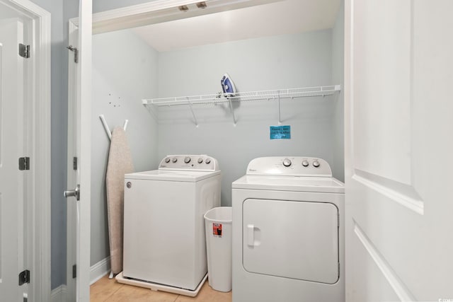 laundry area featuring washing machine and dryer and light tile patterned floors