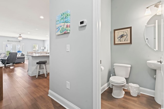 bathroom featuring wood-type flooring, toilet, and ceiling fan