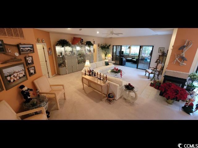 carpeted living room with ceiling fan