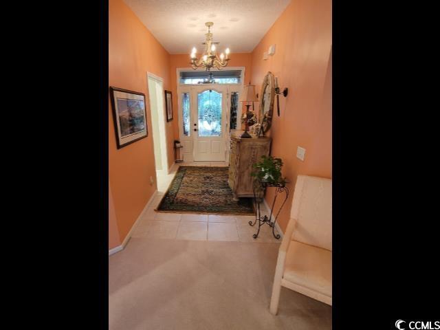 doorway to outside featuring a chandelier and light tile patterned floors