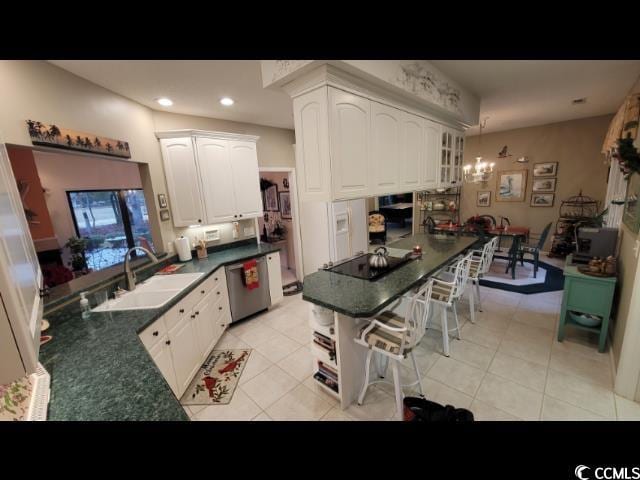 kitchen with sink, dishwasher, white cabinetry, black electric stovetop, and light tile patterned flooring