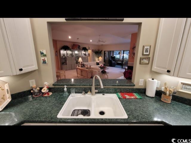 kitchen with white cabinetry, sink, and ceiling fan