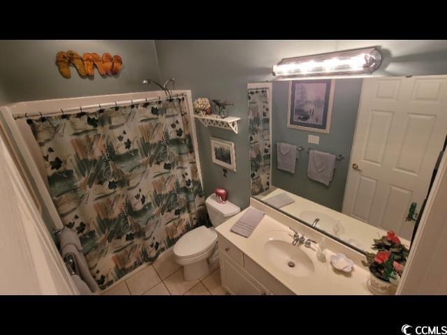 bathroom featuring a shower with curtain, vanity, toilet, and tile patterned flooring