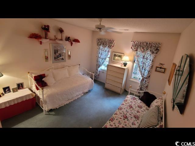 bedroom with ceiling fan and dark colored carpet