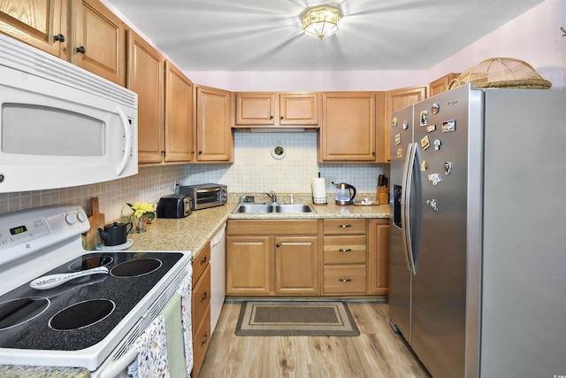 kitchen with white appliances, decorative backsplash, sink, light wood-type flooring, and light stone counters