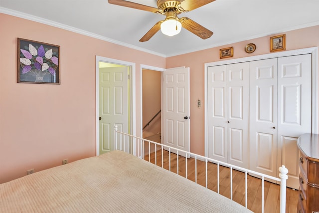 unfurnished bedroom with crown molding, hardwood / wood-style floors, a closet, and ceiling fan