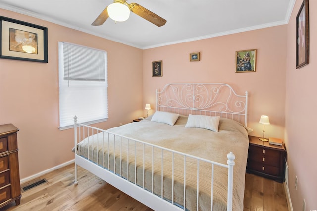 bedroom with ceiling fan, light hardwood / wood-style floors, and crown molding