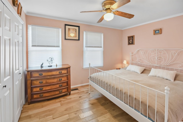 bedroom featuring ceiling fan, light hardwood / wood-style floors, a closet, and ornamental molding