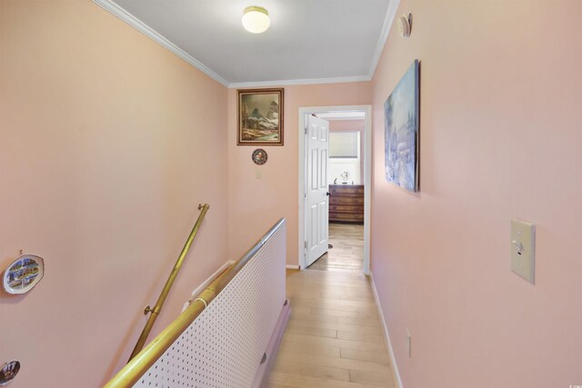 hall with light hardwood / wood-style flooring and crown molding